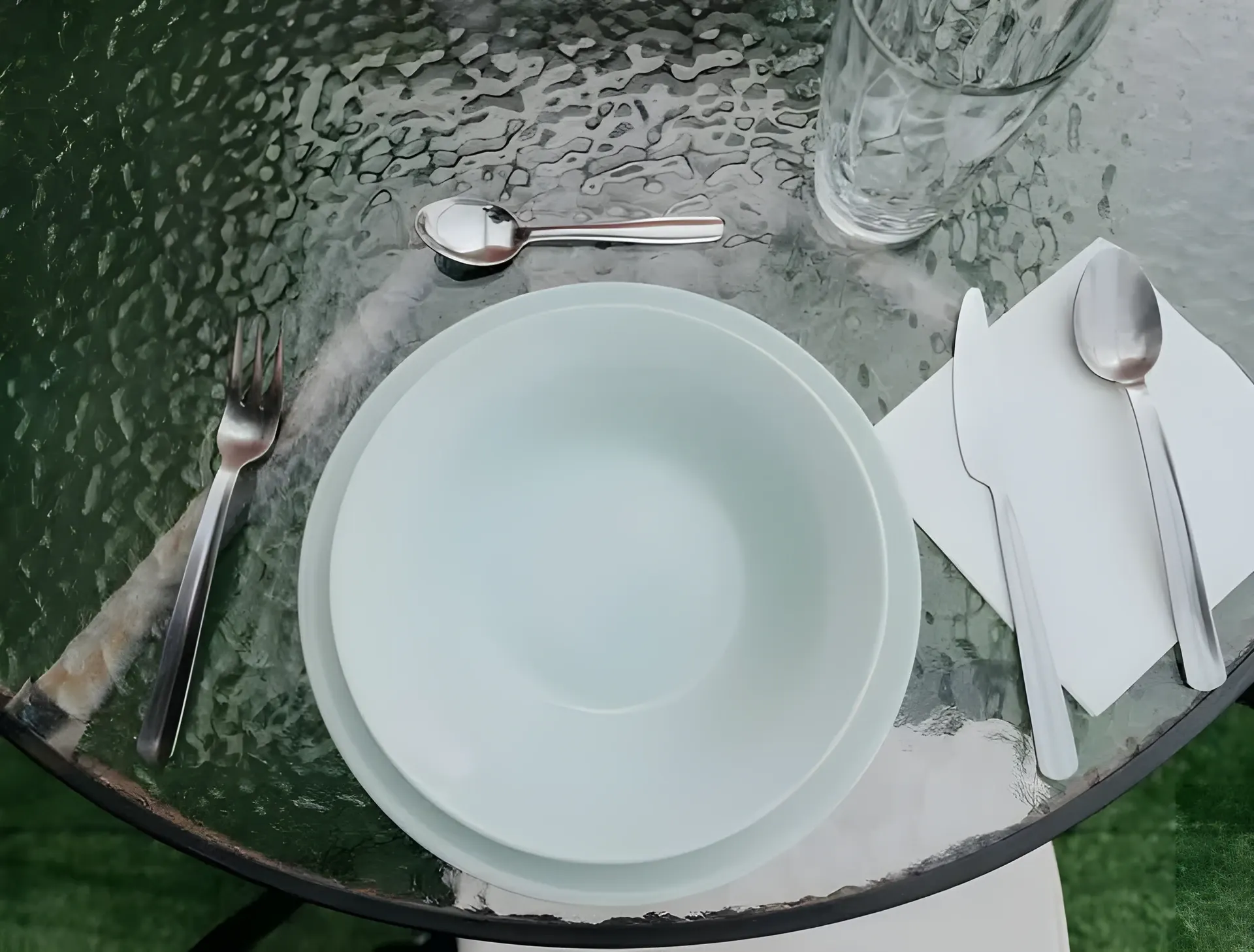 Mesa de cristal de la terraza puesta para comer